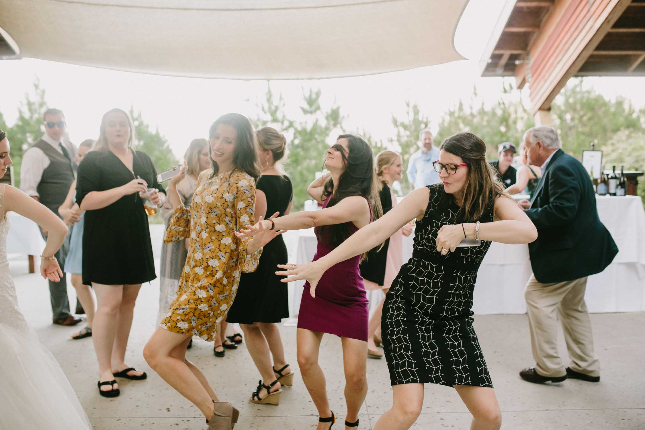 Women dancing on the dance floor at an outdoor wedding.