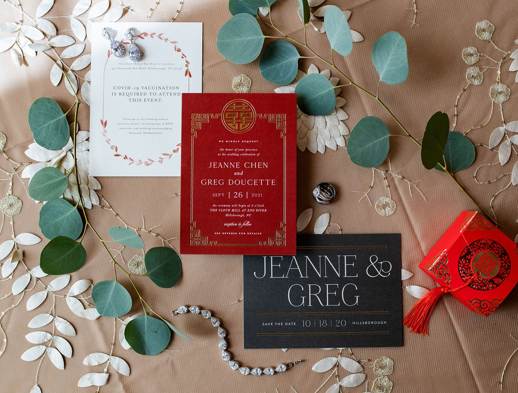 Styled layout of a wedding invitation suite in bold reds and blacks. 
