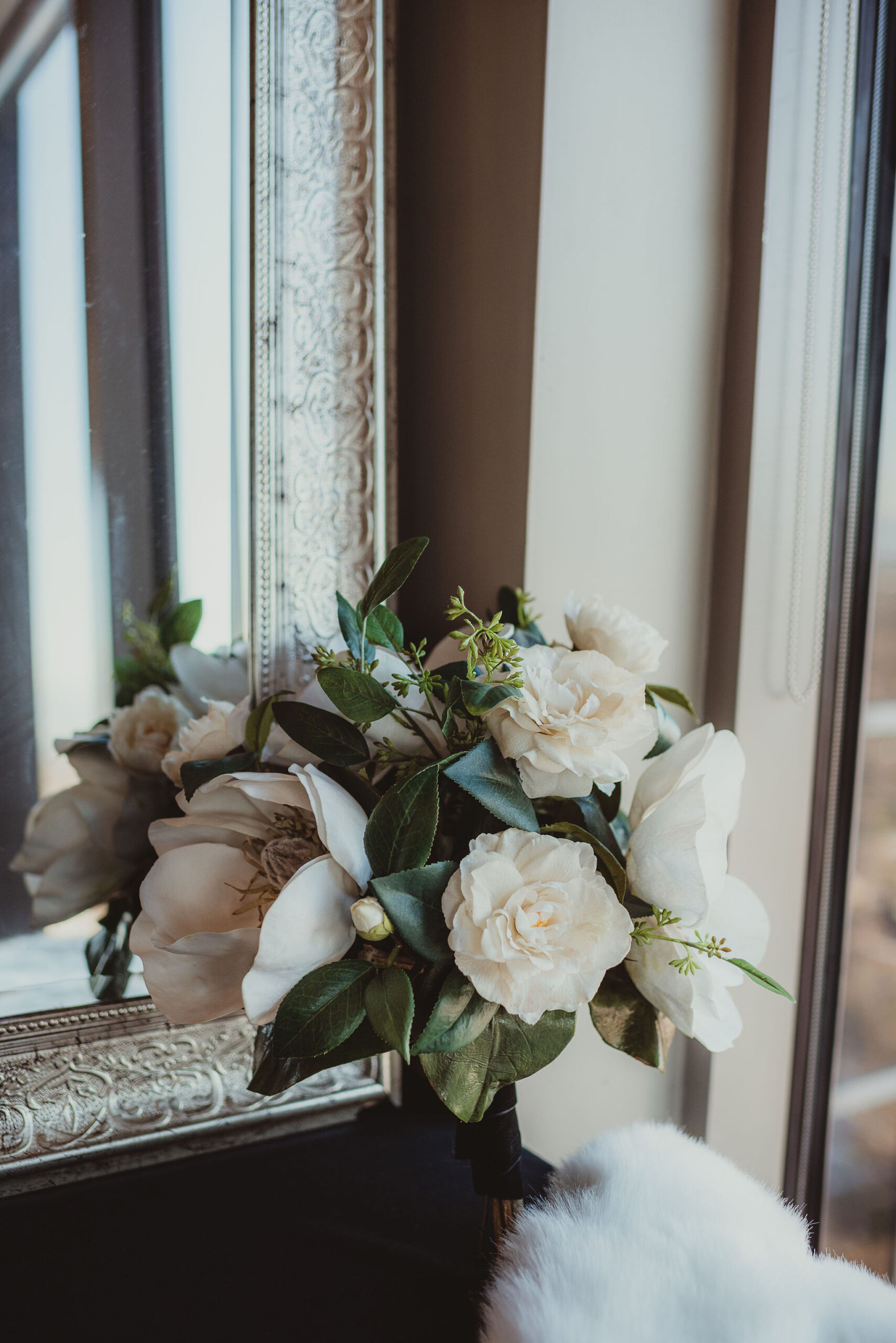 A faux floral bouquet featuring magnolia blooms and greenery.
