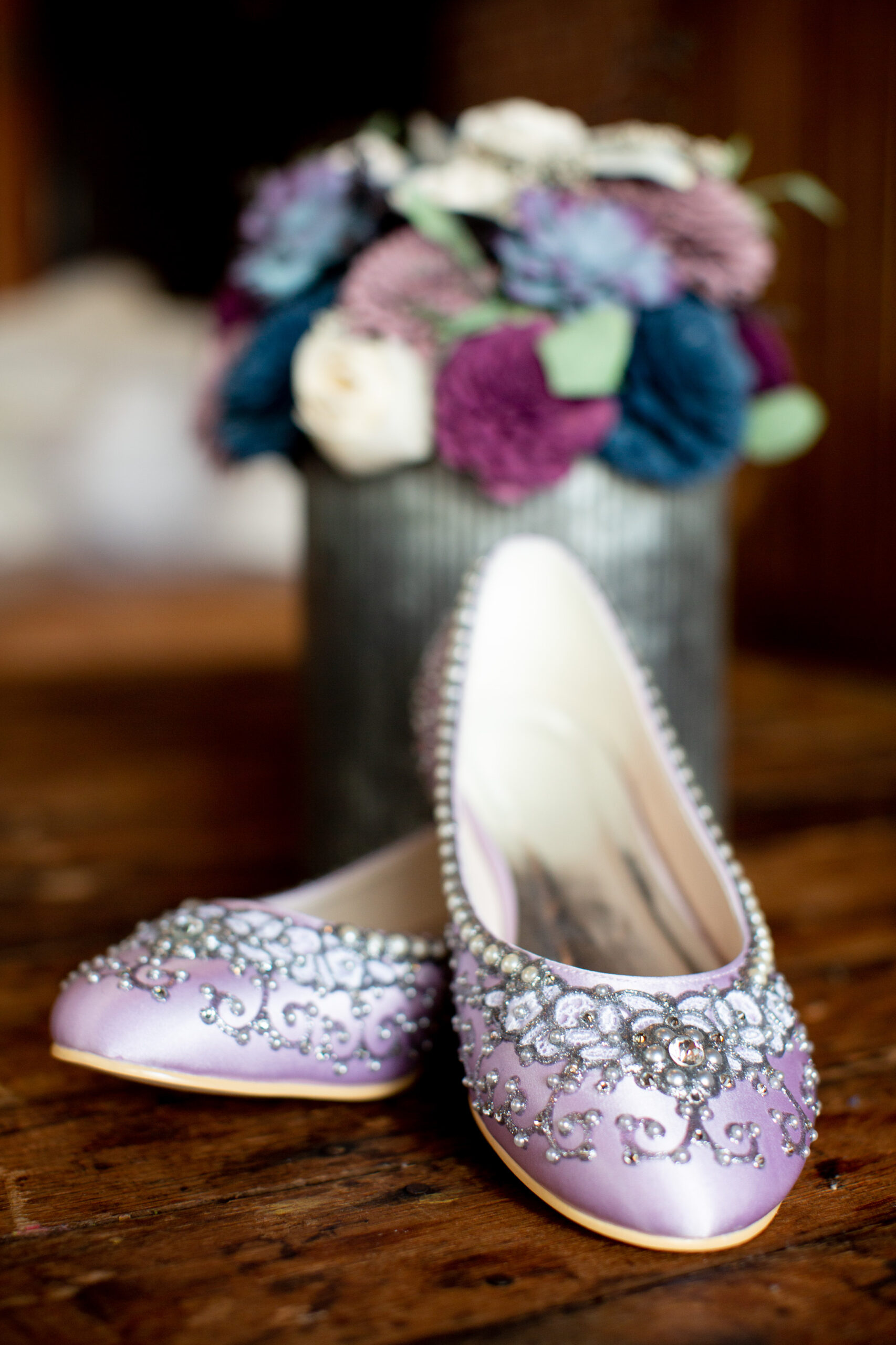 A pair of lavender colored ballet flats with clear rhinestone embellishments. 