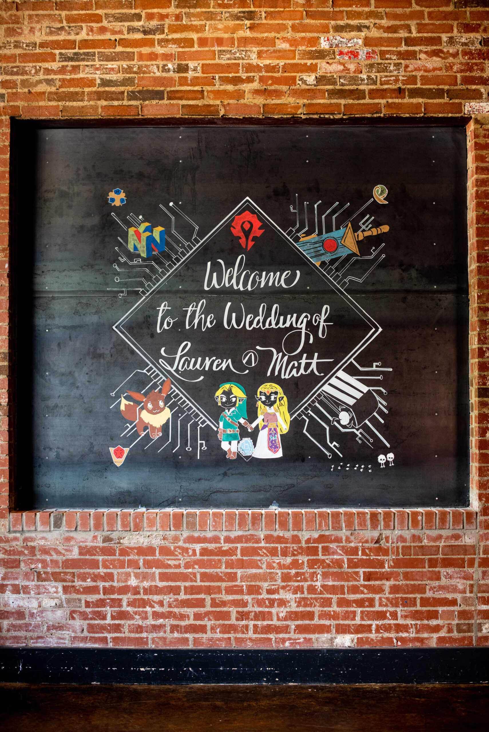 Chalkboard on a brick wall, showing colorful chalk drawings of various video game characters, including Zelda.